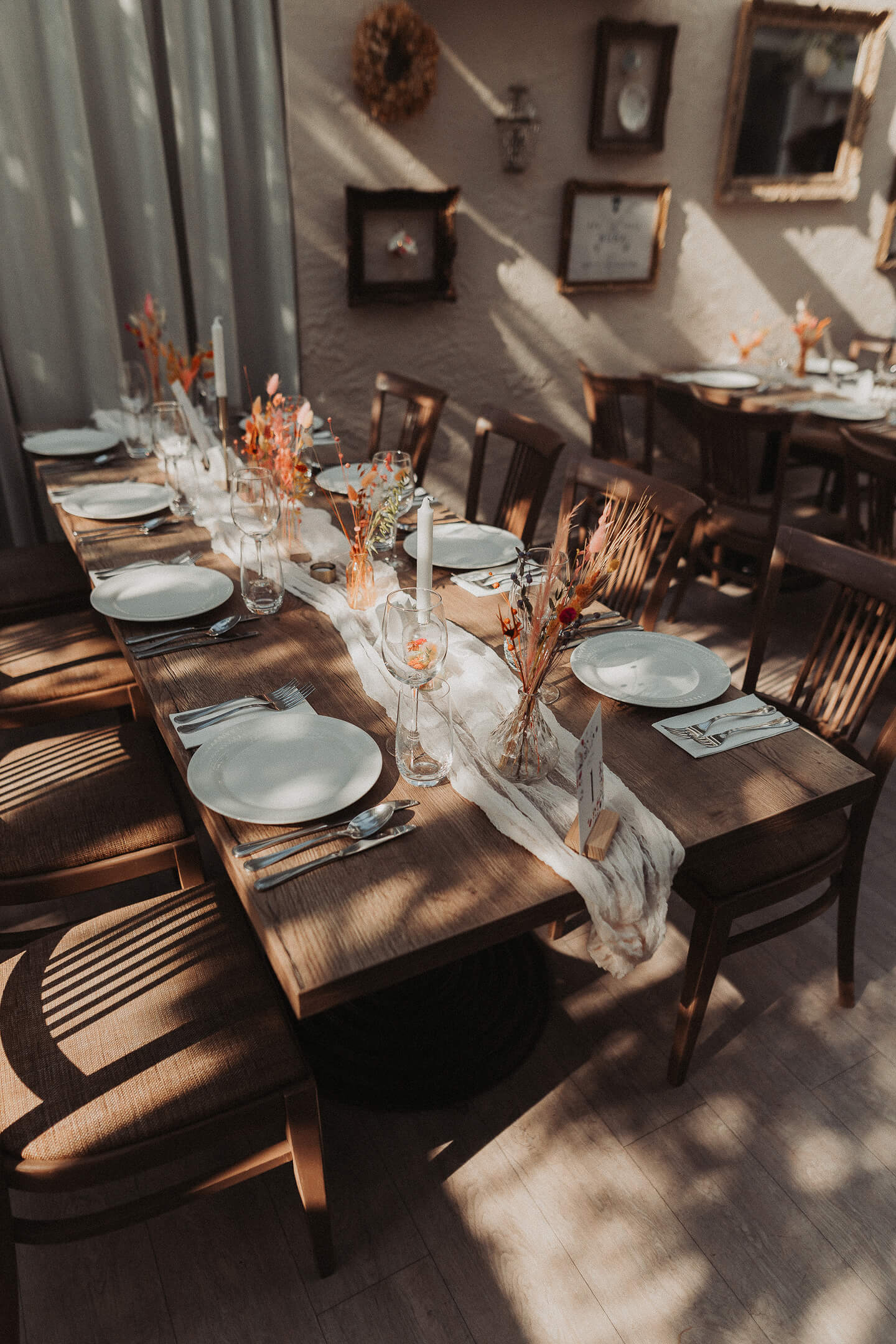An elegantly set wedding dinner table with natural decorations and candles.